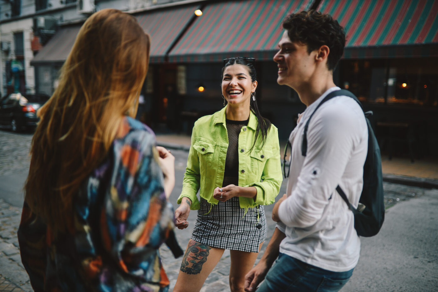 Three young people standing and talking in the city